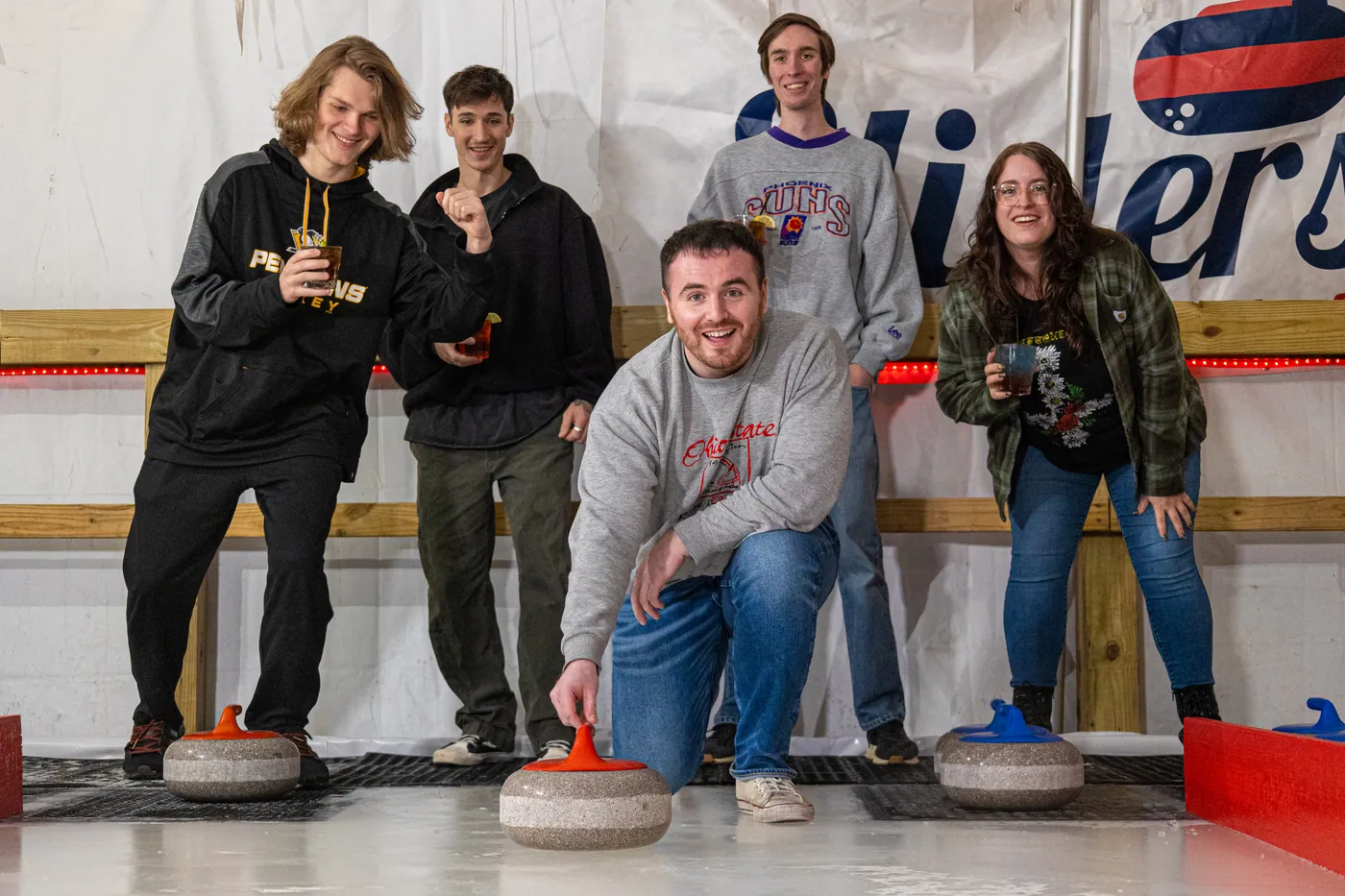 A crew gathered at the end of the curling sheet