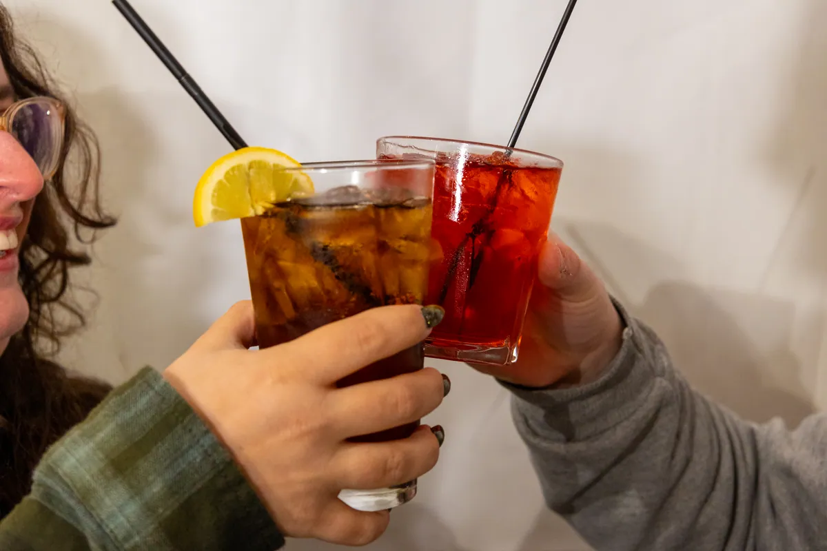 Friends toasting drinks rinkside between ends
